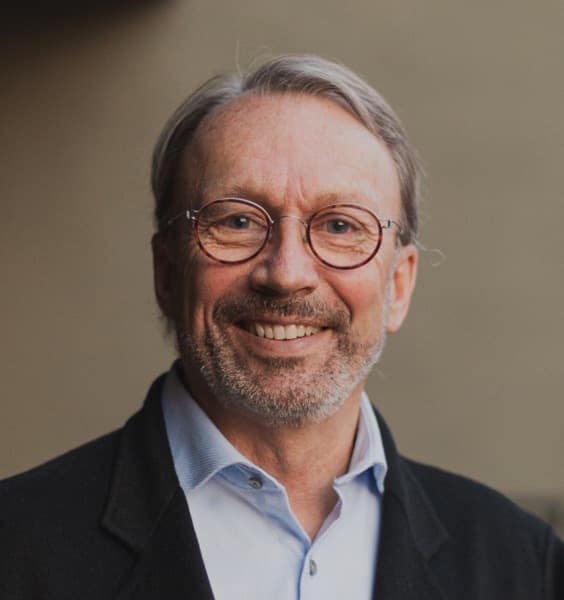 Middle aged white man with glasses smiling looking at the camera